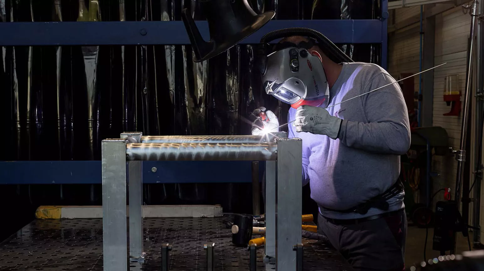 Man welds in a dark room