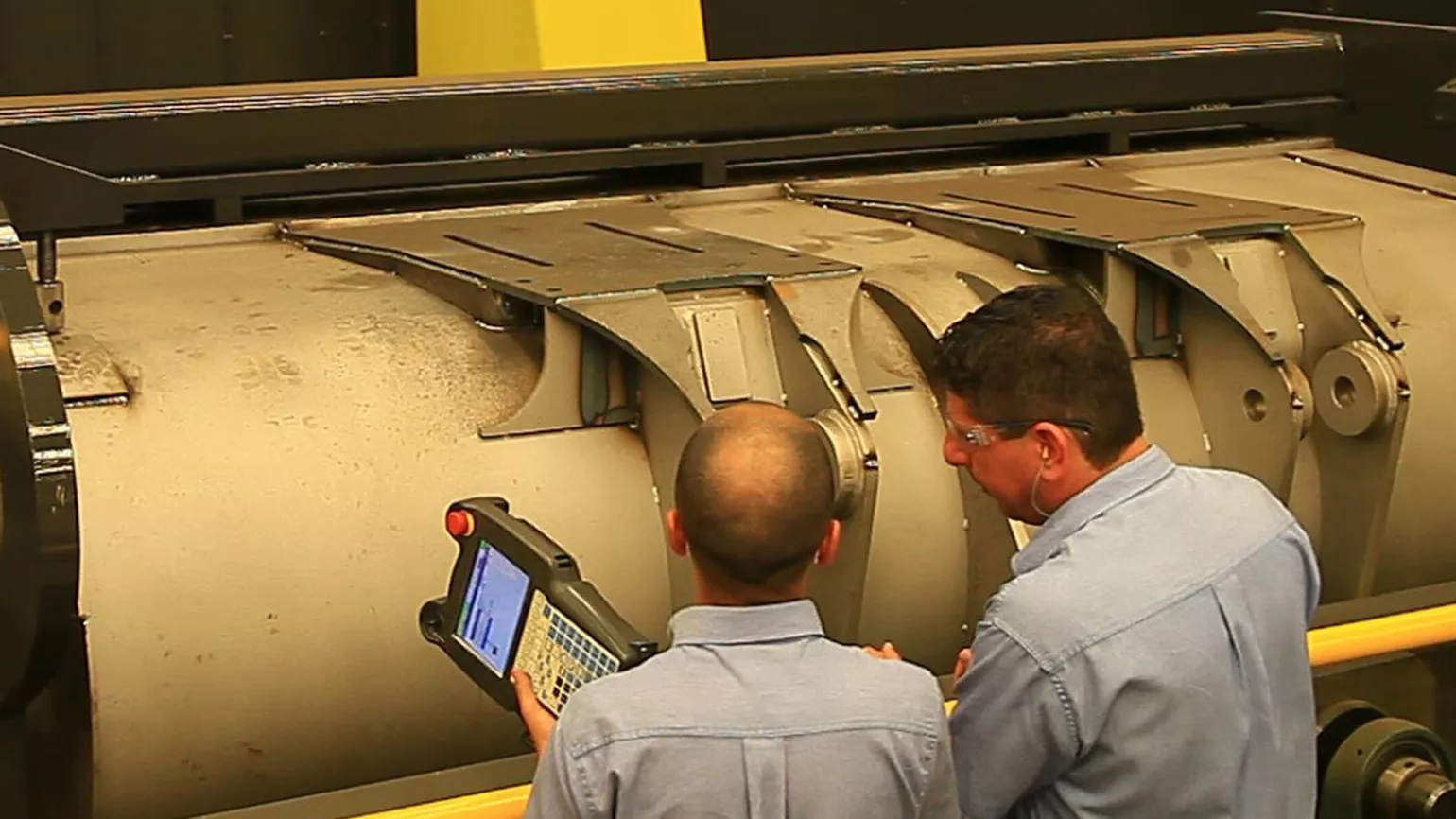 Two employees inspect the excavator shovel