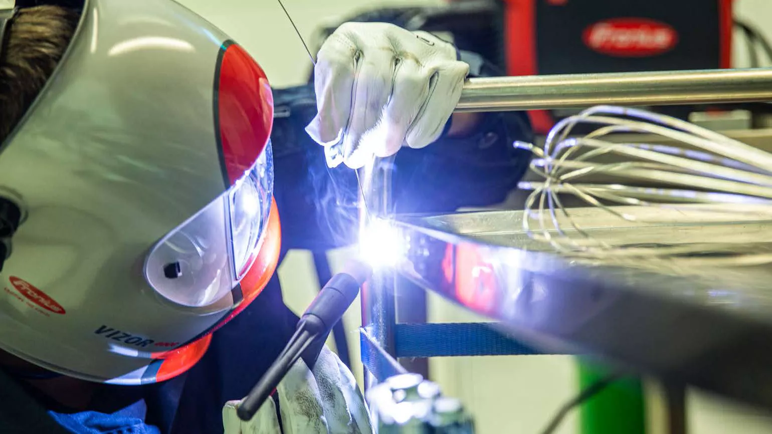 A welder welds a workpiece.