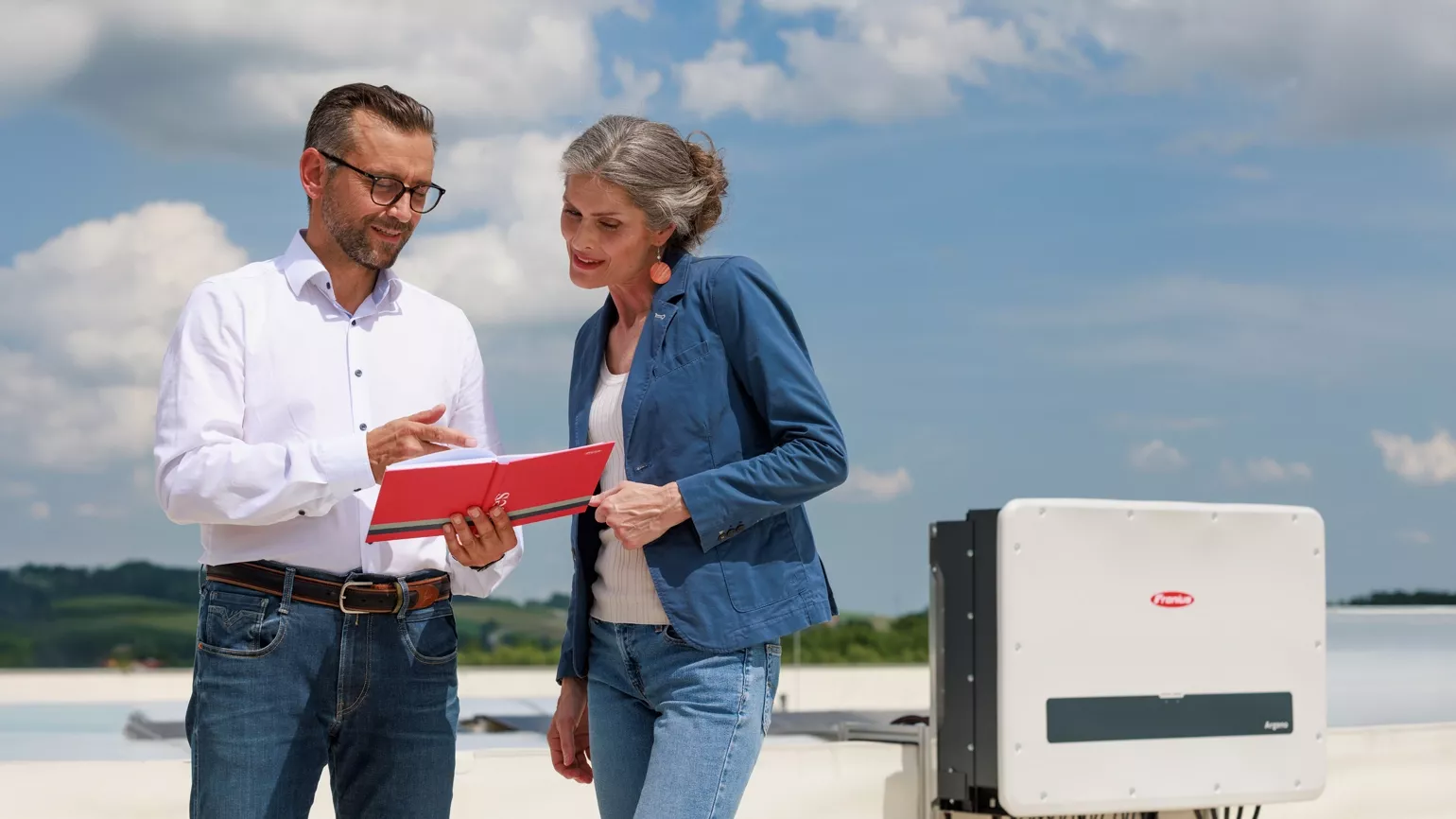Customer and installer on roof with inverter in background