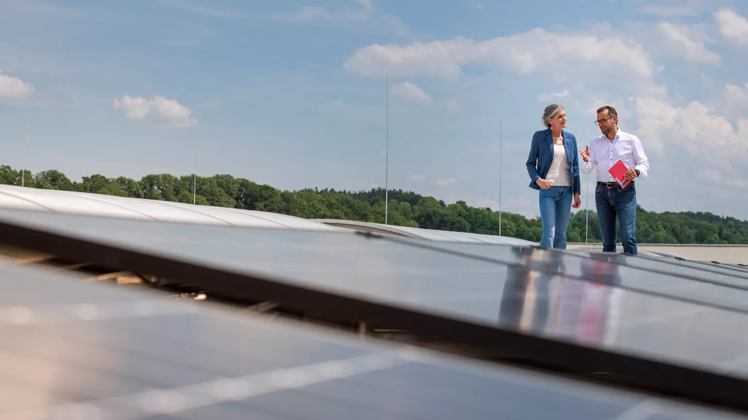 Business owner in front of pv modules on roof