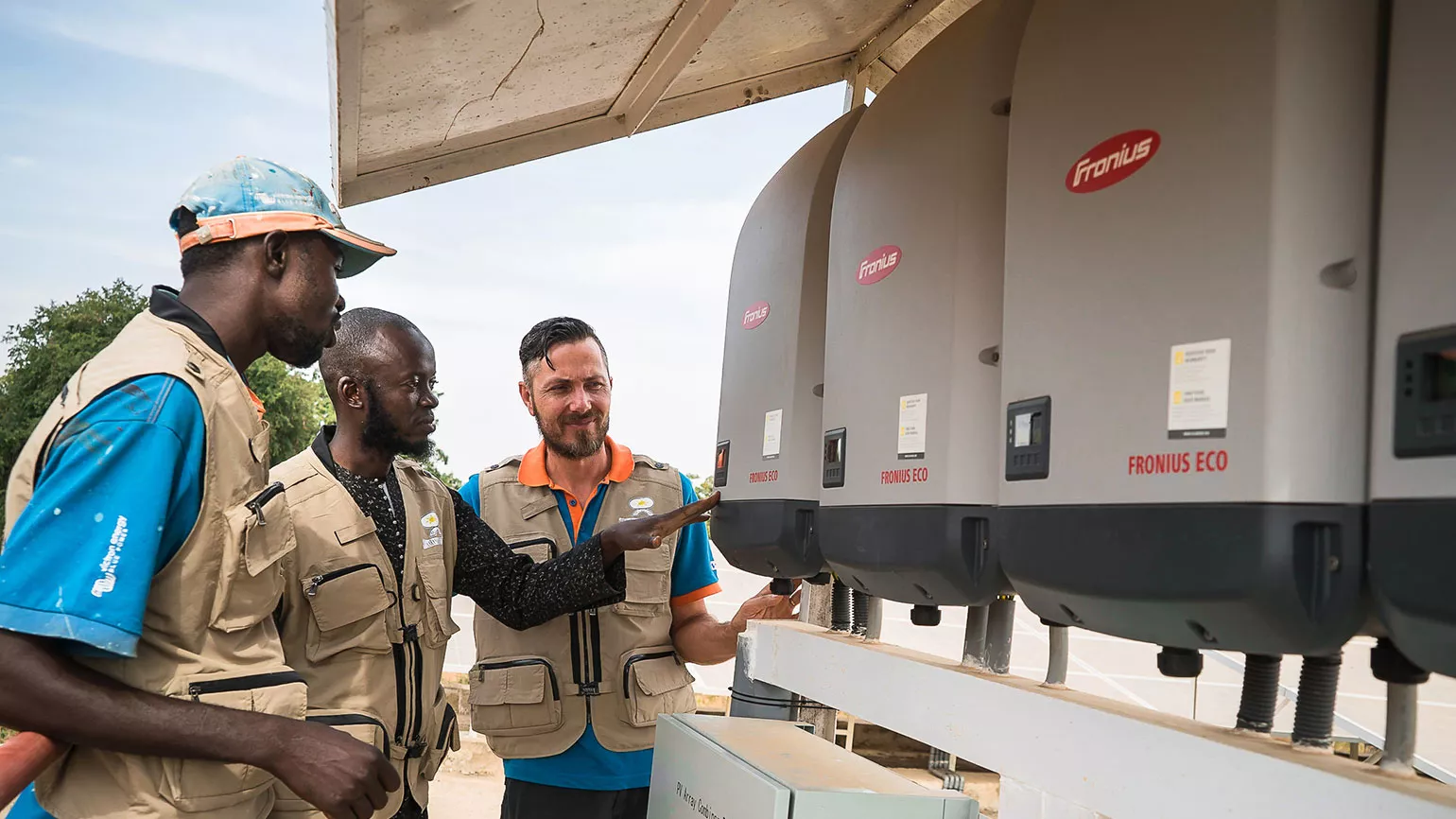 men in front of inverter in Mali